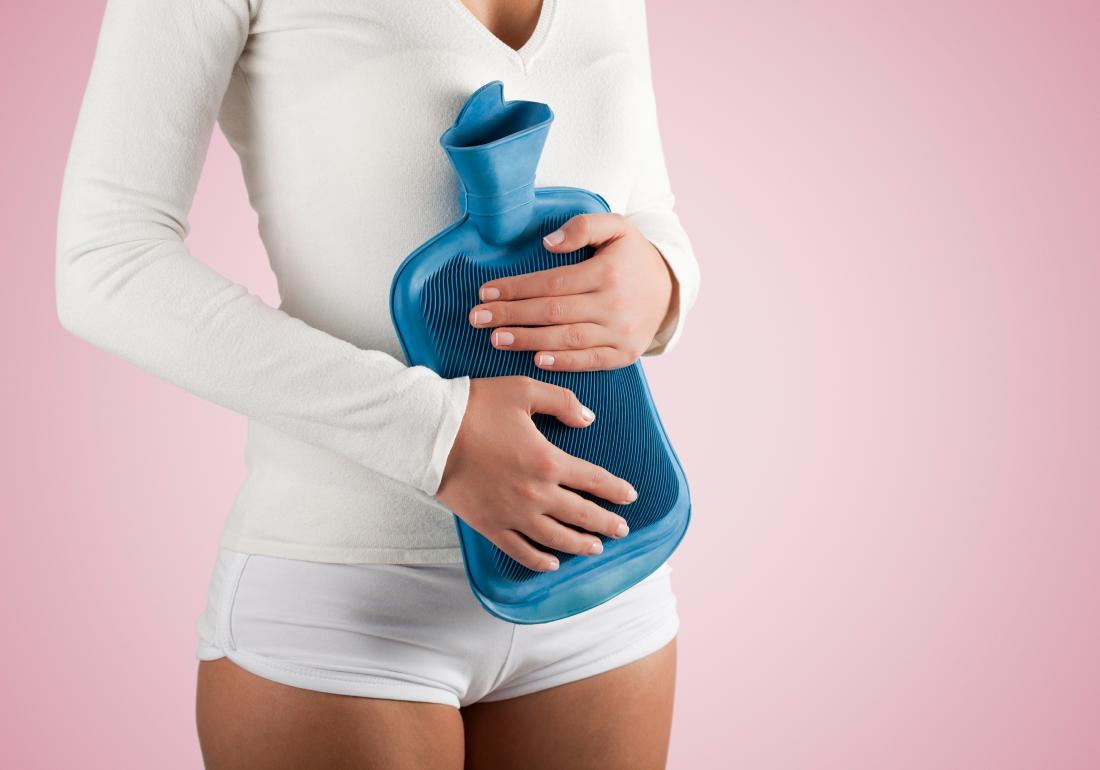 Woman holding water bottle to stomach