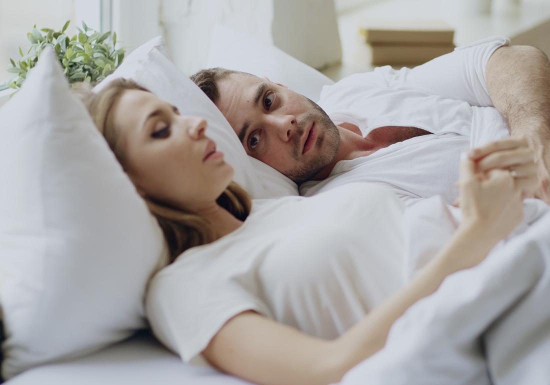Man and woman laying in bad talking