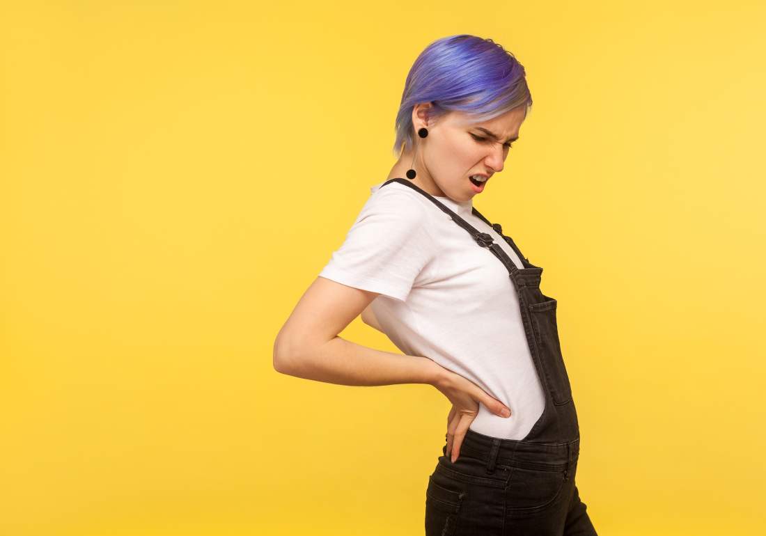 Woman holding bottom of back due to endo symptoms