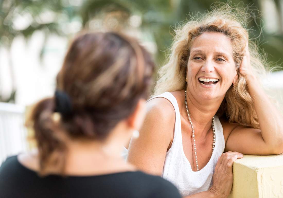 Woman smiling talking with friend about endometriosis