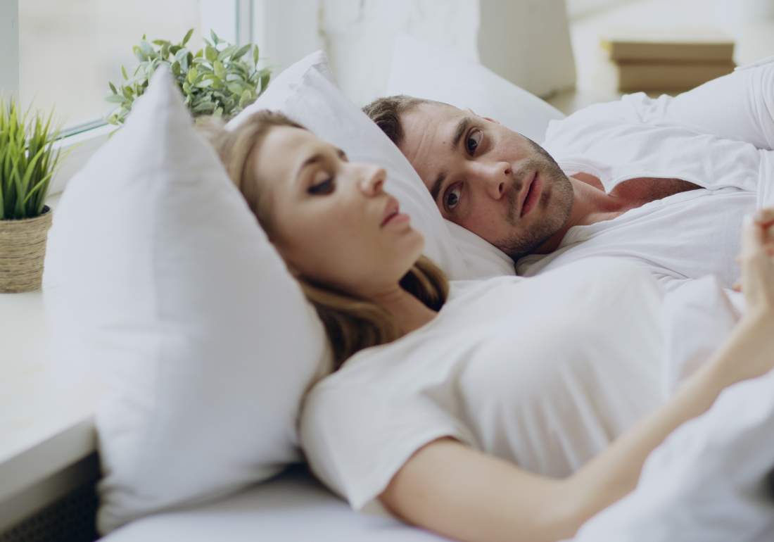 Man and woman laying in bad talking