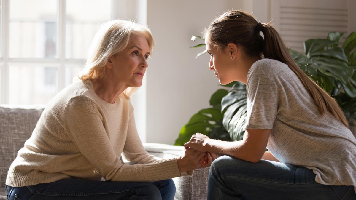 Older and younger woman speaking seriously
