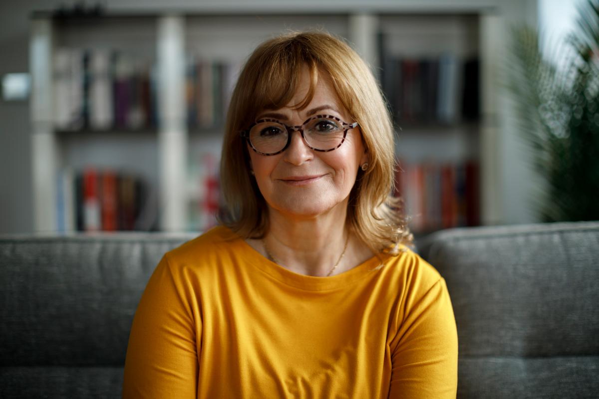 Middle aged woman with glasses smiling at the camera