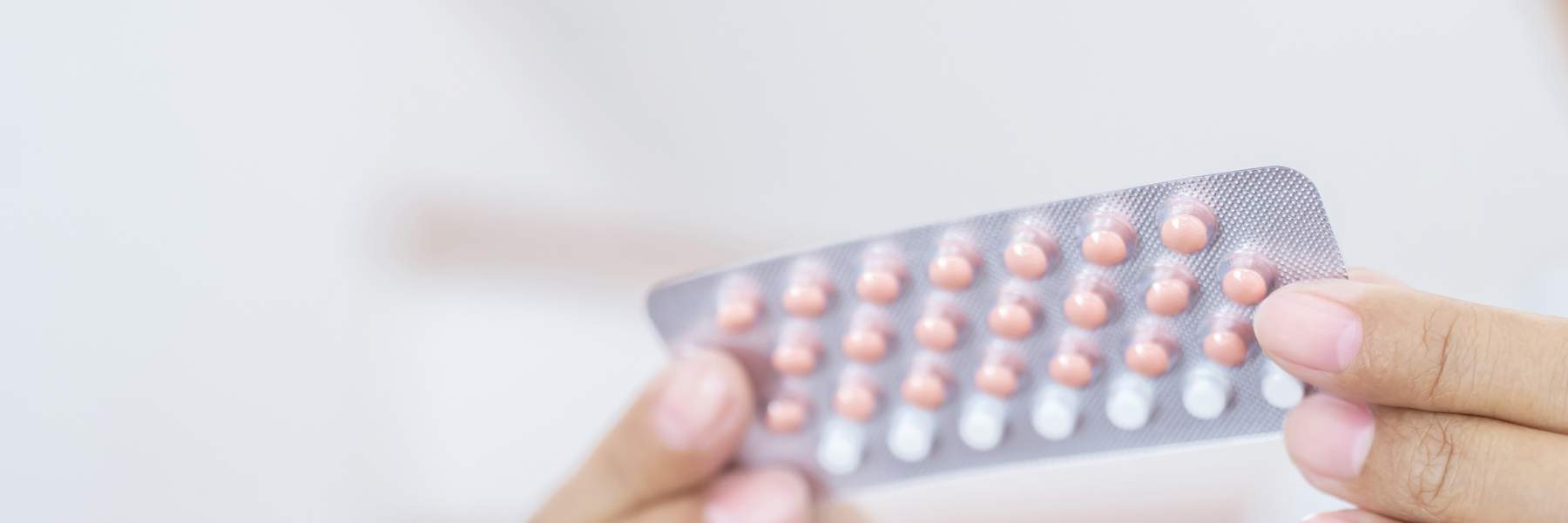 Girl holding combined oral contraceptive pill