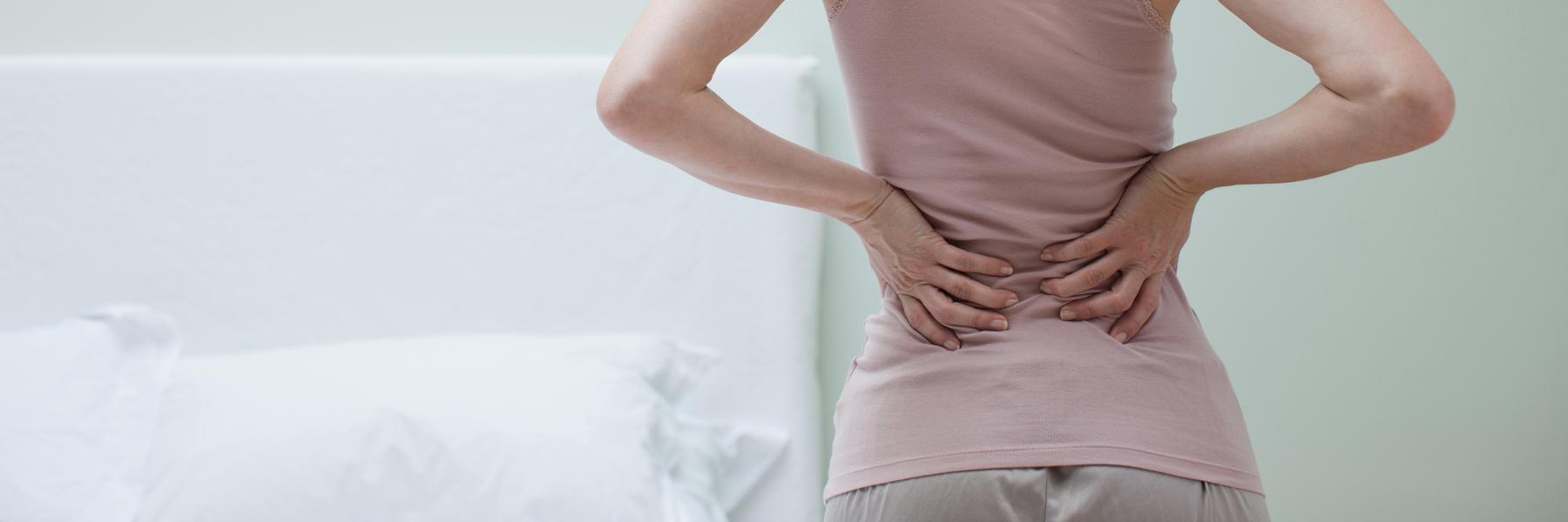 Woman holding bottom of back due to endo symptoms
