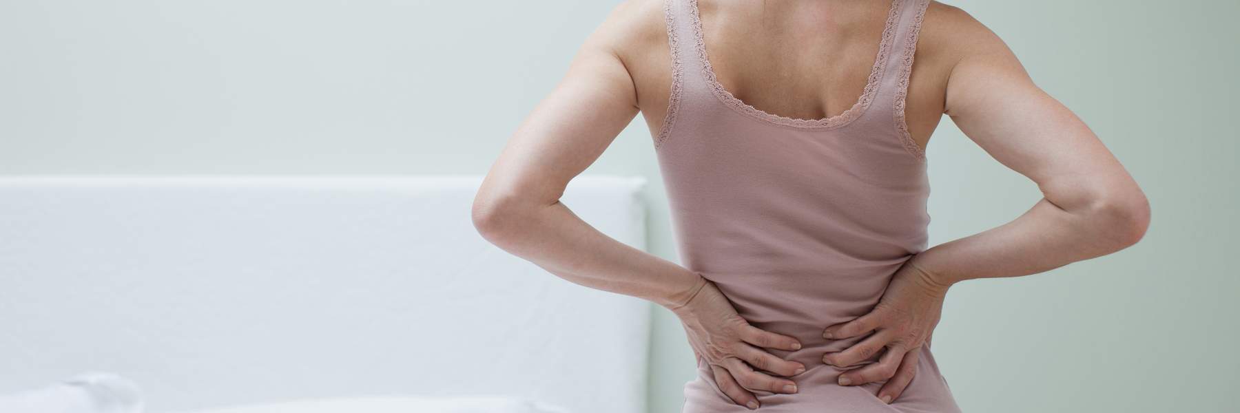 Woman holding bottom of back due to endo symptoms
