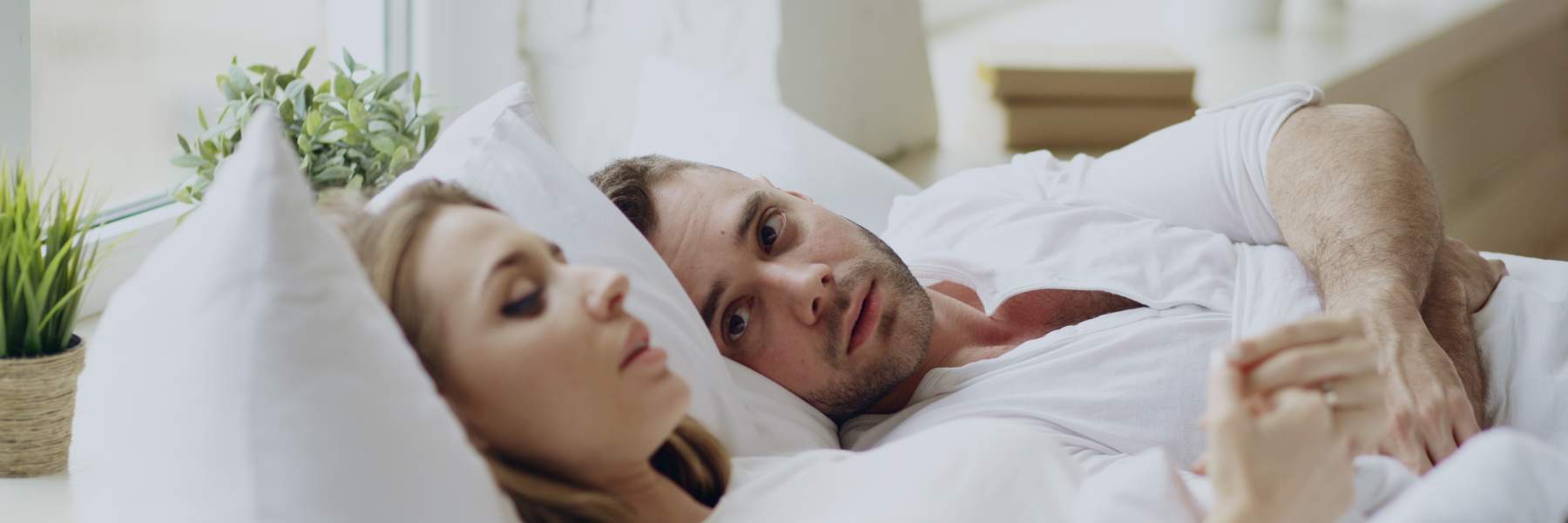 Man and woman laying in bad talking