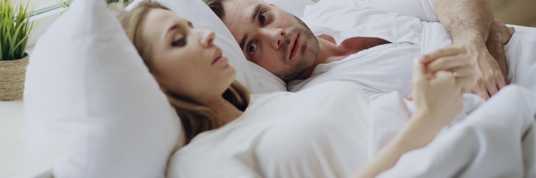 Man and woman laying in bad talking