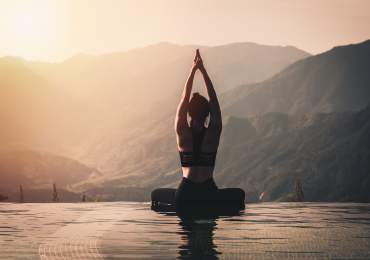 Woman doing yoga with mountains in background