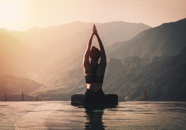 Woman doing yoga with mountains in background