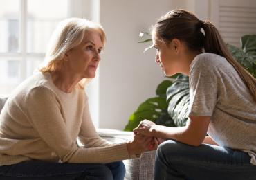 Older and younger woman speaking seriously