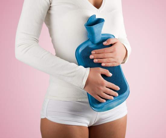 Woman holding water bottle to stomach