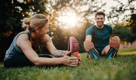  Man and woman doing exercises on the grass