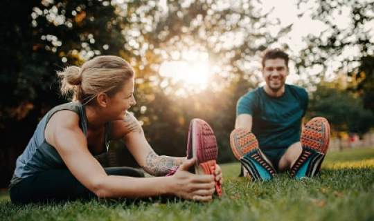  Man and woman doing exercises on the grass