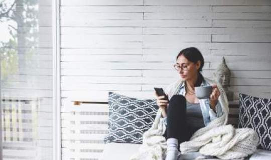 woman sitting with phone and coffee